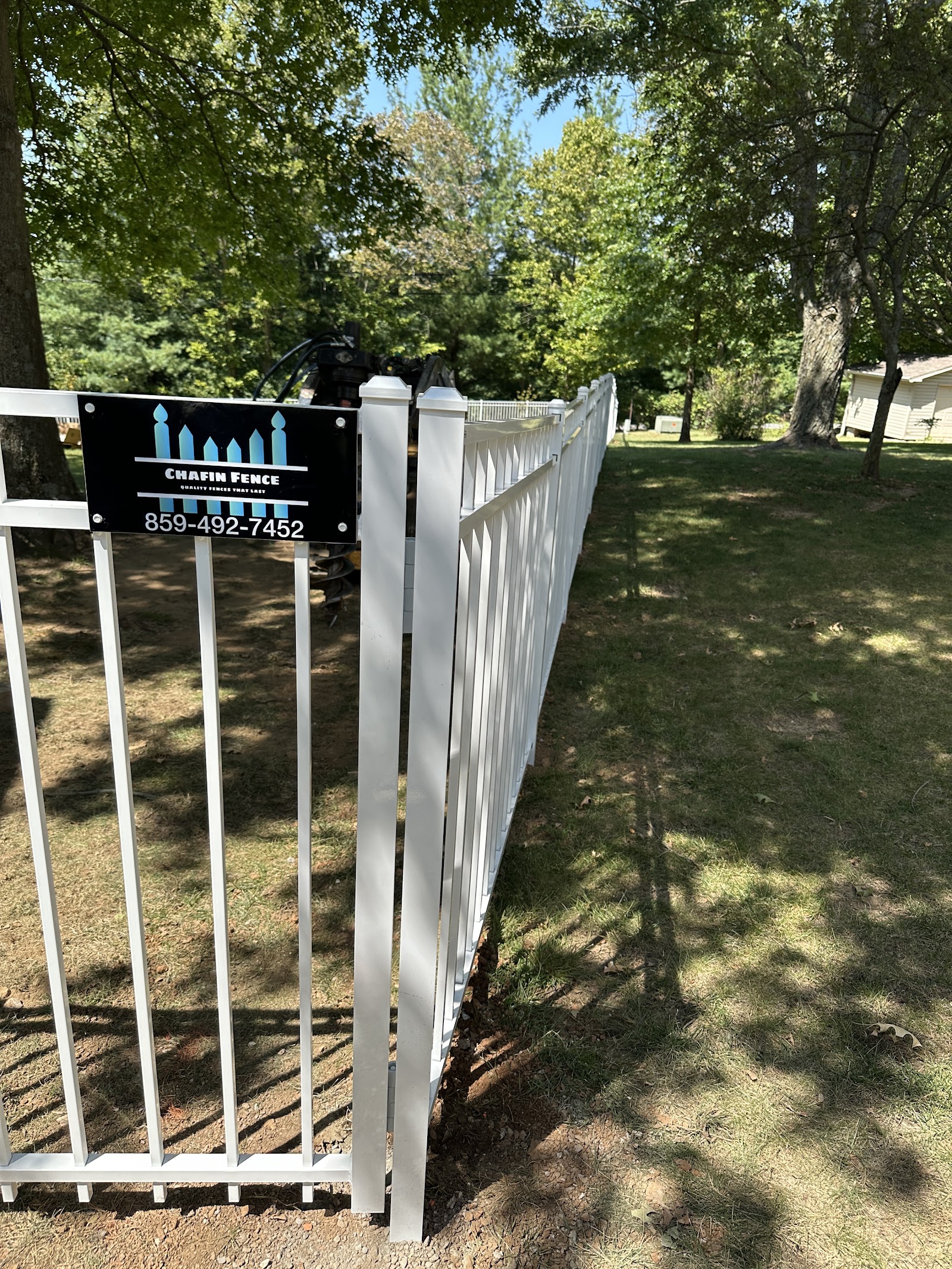 White ornamental aluminum fence beside a lawn