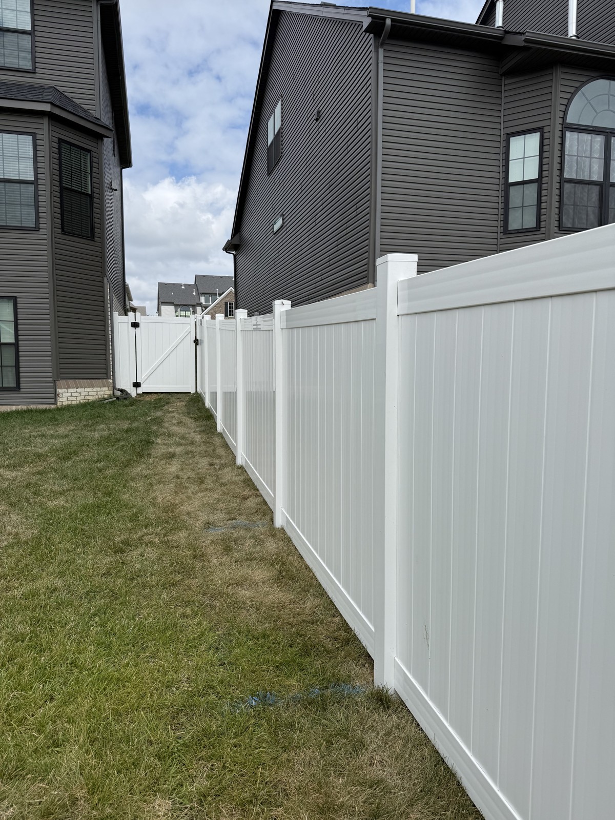 White vinyl privacy fence and matching gate between homes